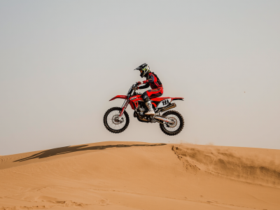 Dirt bike motorcycle rider jumping over desert dunes in Dubai, extreme sports action, motocross in sand, high jump, thrilling adventure, professional photography (1)