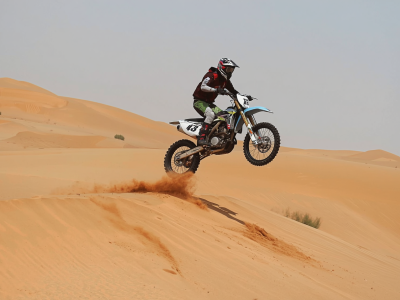 Dirt bike motorcycle rider jumping over desert dunes in Dubai, extreme sports action, motocross in sand, high jump, thrilling adventure, professional photography (3)